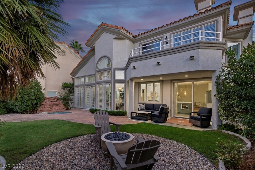 8848 Rainbow Ridge Drive, Las Vegas, NV 89117 An inviting backyard patio sits beneath the elegant stucco exterior of a two-story home.