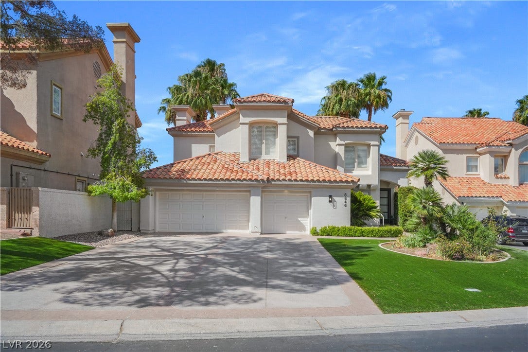 8848 Rainbow Ridge Drive, Las Vegas, NV 89117 Spanish tile roofs and a wide concrete driveway define this elegant two-story exterior.