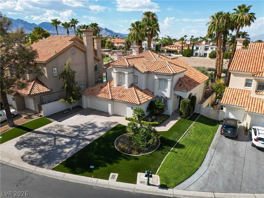 8848 Rainbow Ridge Drive, Las Vegas, NV 89117 Spanish tile roofs and manicured lawns frame this desert oasis against a mountain backdrop.