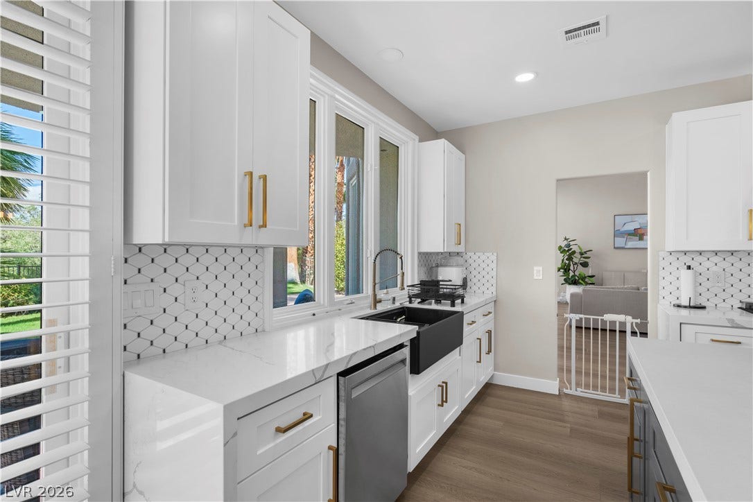 8848 Rainbow Ridge Drive, Las Vegas, NV 89117 Gleaming stone countertops and crisp white cabinetry line this modern kitchen space.
