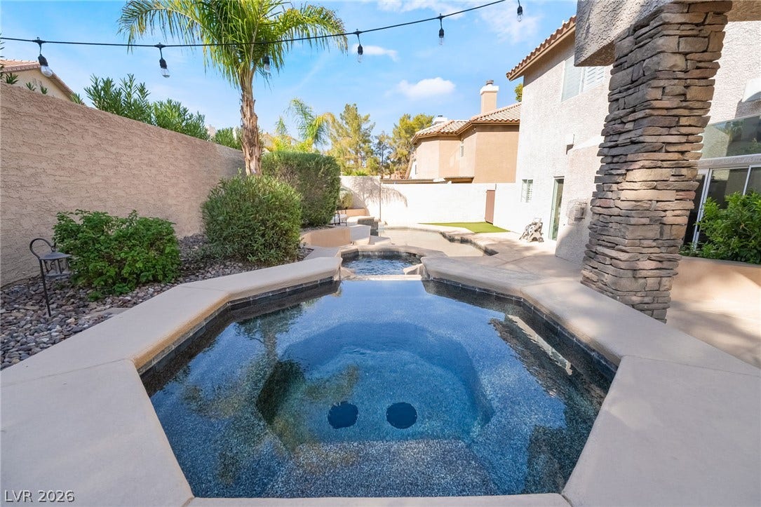 826 Rising Star Drive, Henderson, NV 89014 An inviting elevated spa spills directly into the swimming pool below within a private courtyard.