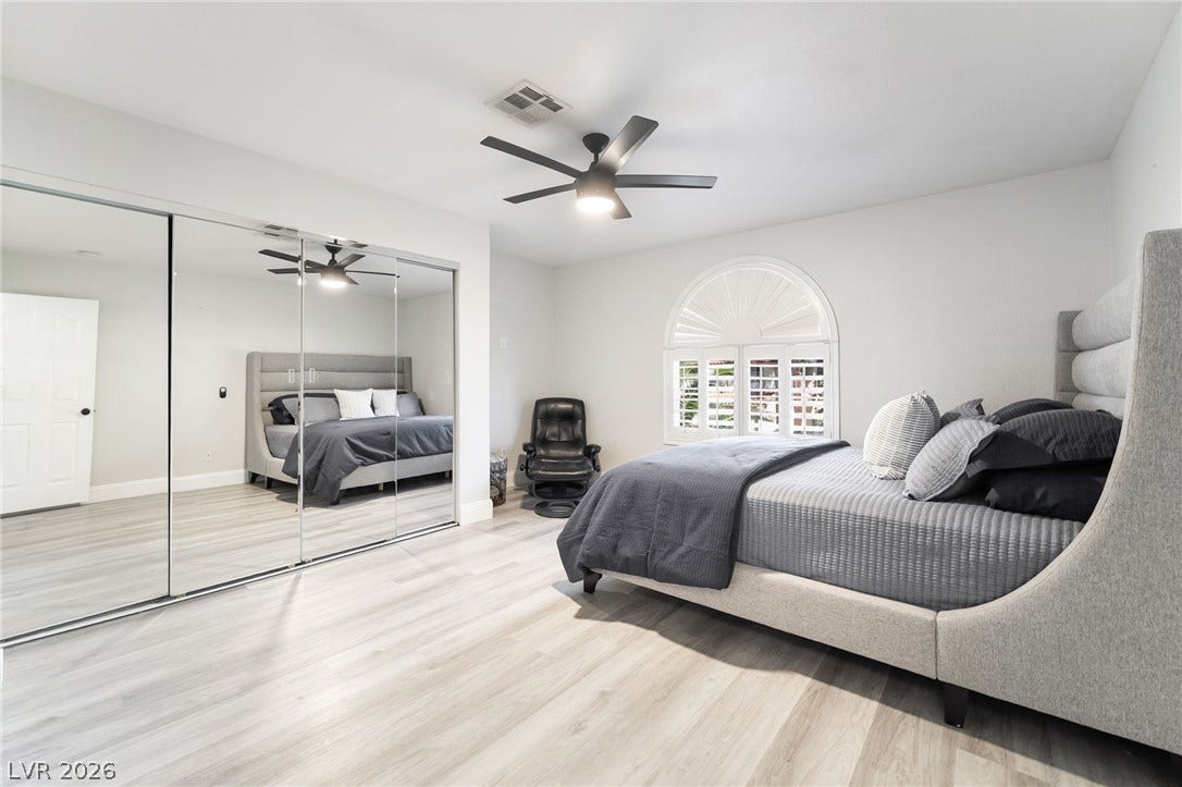 826 Rising Star Drive, Henderson, NV 89014 Smooth wood-look flooring and a classic arched window establish a refined tone in this bedroom.