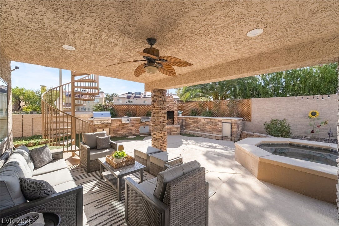 826 Rising Star Drive, Henderson, NV 89014 An inviting covered patio integrates an outdoor kitchen and a built-in spa under a stucco ceiling.