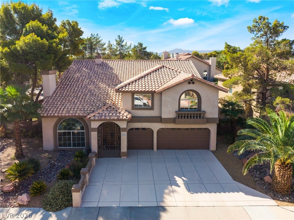 826 Rising Star Drive, Henderson, NV 89014 Spanish tile roofing and an expansive paved driveway highlight this multi-level stucco home.