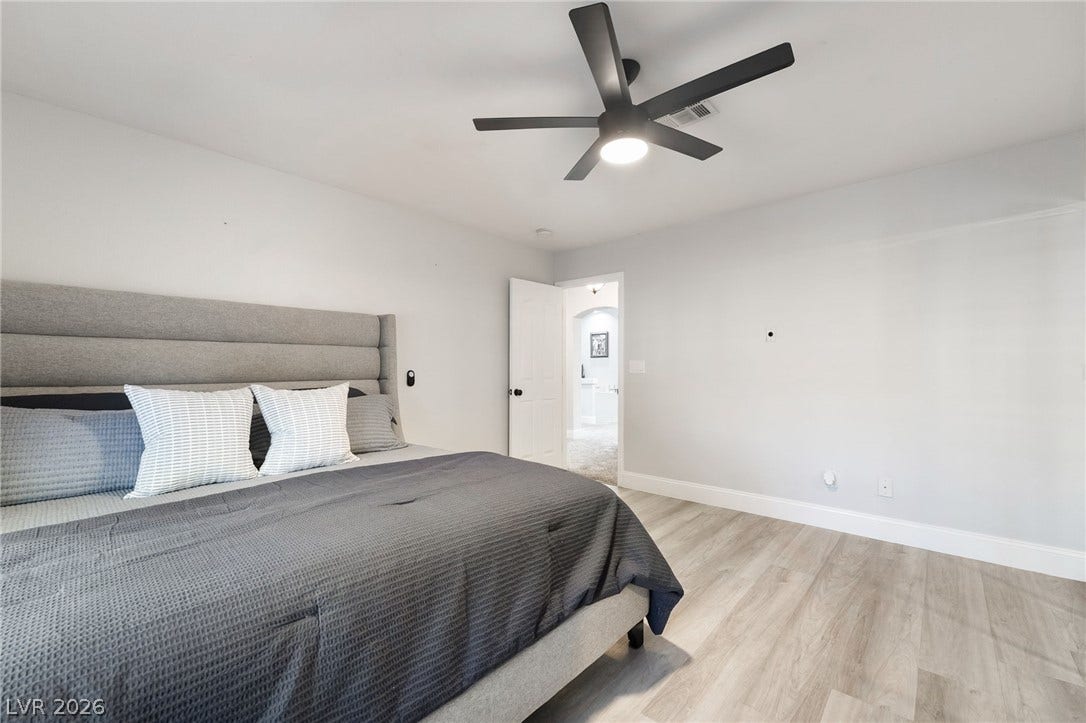 826 Rising Star Drive, Henderson, NV 89014 Smooth wood-look flooring and clean lines define this serene, minimalist bedroom space.