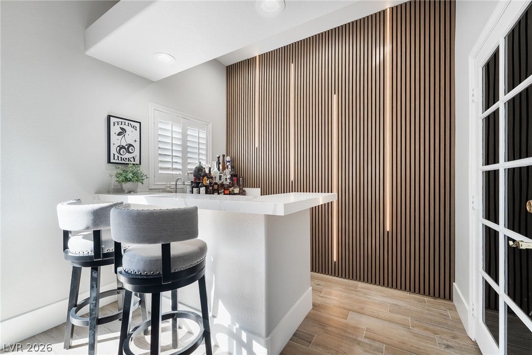 826 Rising Star Drive, Henderson, NV 89014 Custom wood paneling and recessed lighting elevate this modern home bar area.