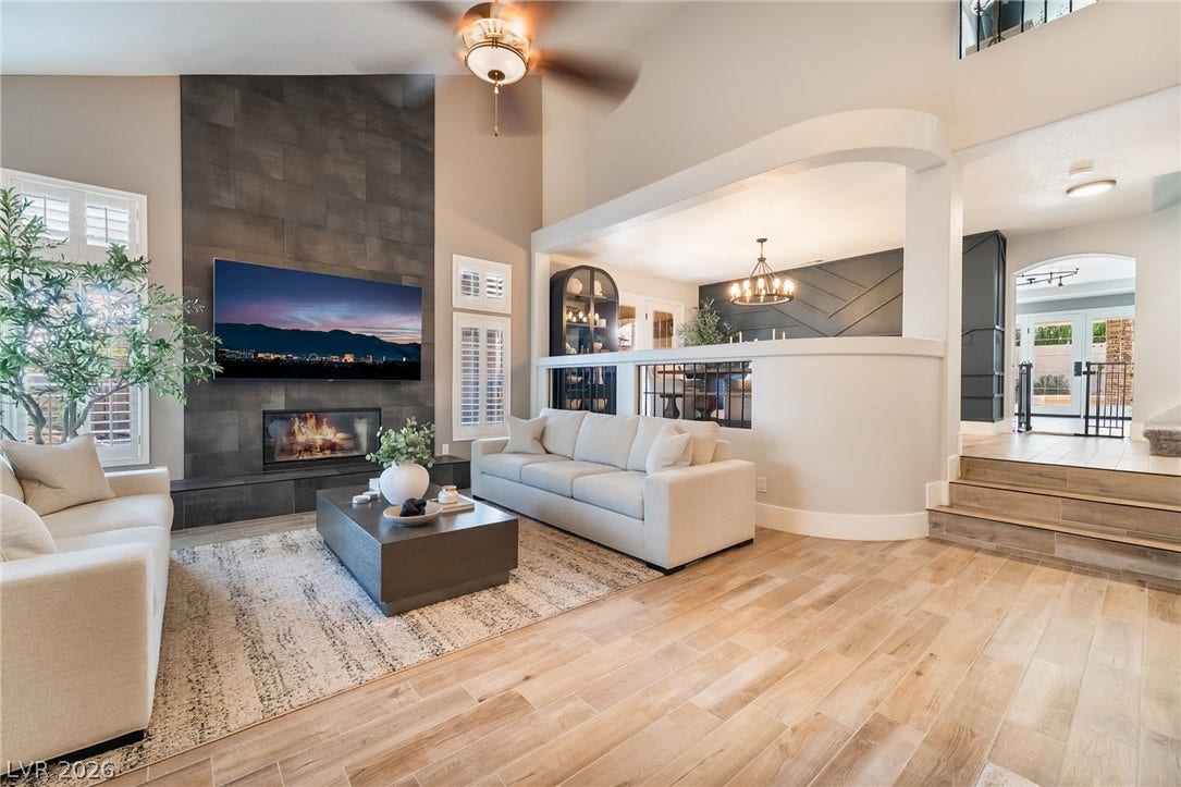 826 Rising Star Drive, Henderson, NV 89014 An open floor plan seamlessly connects the living space and raised dining area over wood flooring.