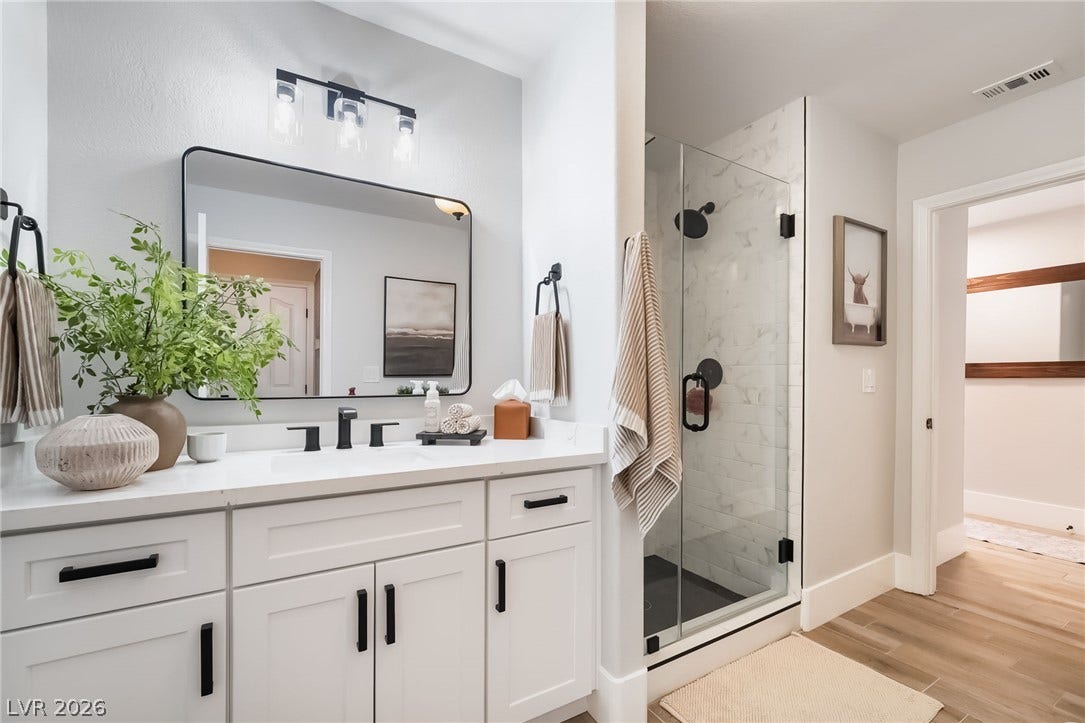 826 Rising Star Drive, Henderson, NV 89014 A glass-enclosed walk-in shower stands adjacent to a white vanity with stone counters.