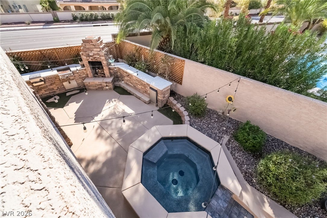 826 Rising Star Drive, Henderson, NV 89014 An inviting stone fireplace and private spa anchor this beautifully designed concrete patio courtyard.