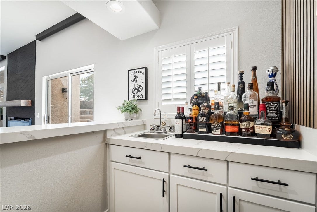 826 Rising Star Drive, Henderson, NV 89014 Stone counters and a built-in sink define this elegant home bar area.