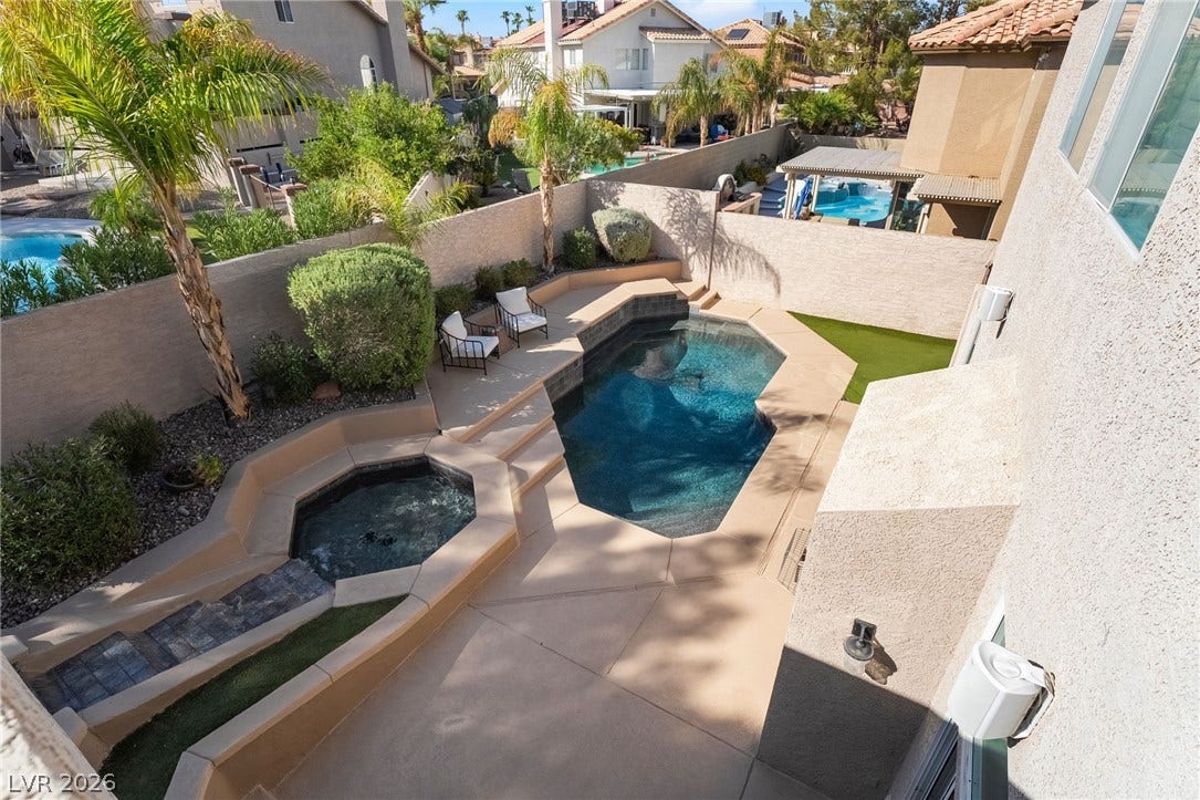 826 Rising Star Drive, Henderson, NV 89014 An inviting backyard oasis features a geometric pool, integrated spa, and concrete decking.