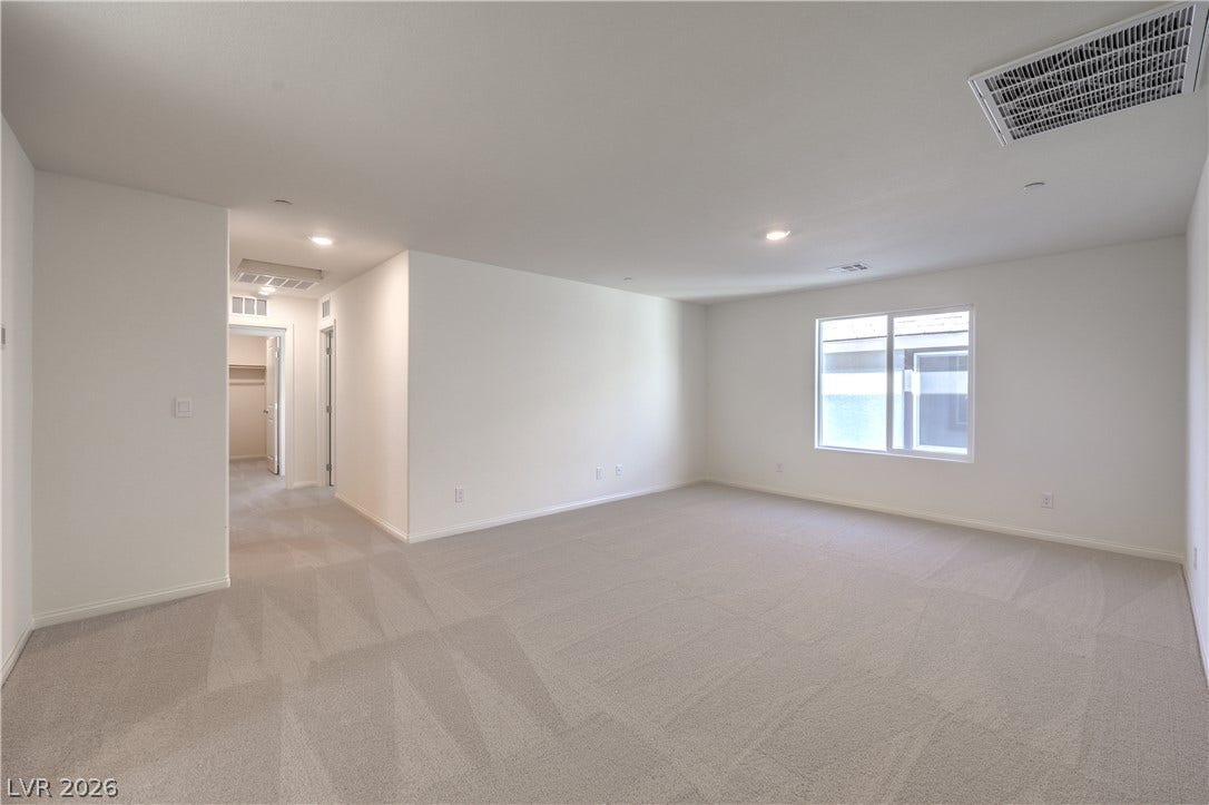 561 Ivory Peacock Ct, Henderson, NV 89011 Plush carpeting anchors this versatile living space illuminated by recessed lighting and natural window light. Photos are of a model home and are for representational purposes only.