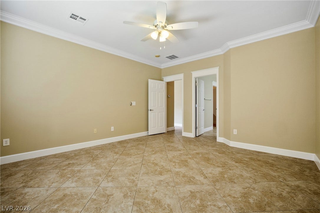 2247 Shadow Canyon Drive, Henderson, NV 89044 Diagonal tile flooring and classic crown molding elevate this versatile bedroom.