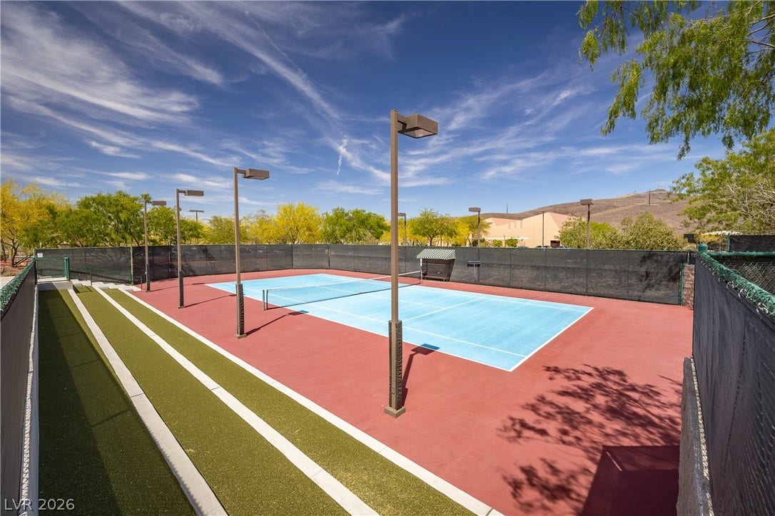 2247 Shadow Canyon Drive, Henderson, NV 89044 A well-maintained outdoor tennis court features professional lighting under a vast desert sky.