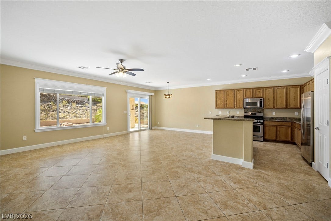 2247 Shadow Canyon Drive, Henderson, NV 89044 An open floor plan connects the kitchen and main living spaces over continuous tile flooring.