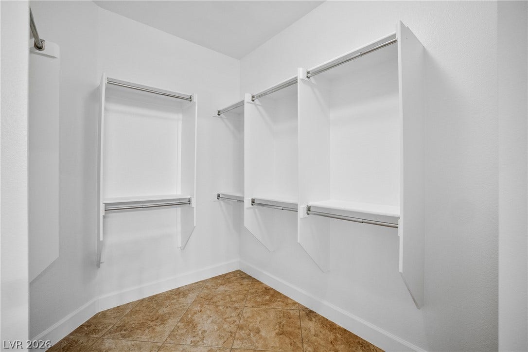 2247 Shadow Canyon Drive, Henderson, NV 89044 Custom built-in shelving and hanging rods maximize storage above tiled flooring in this closet.
