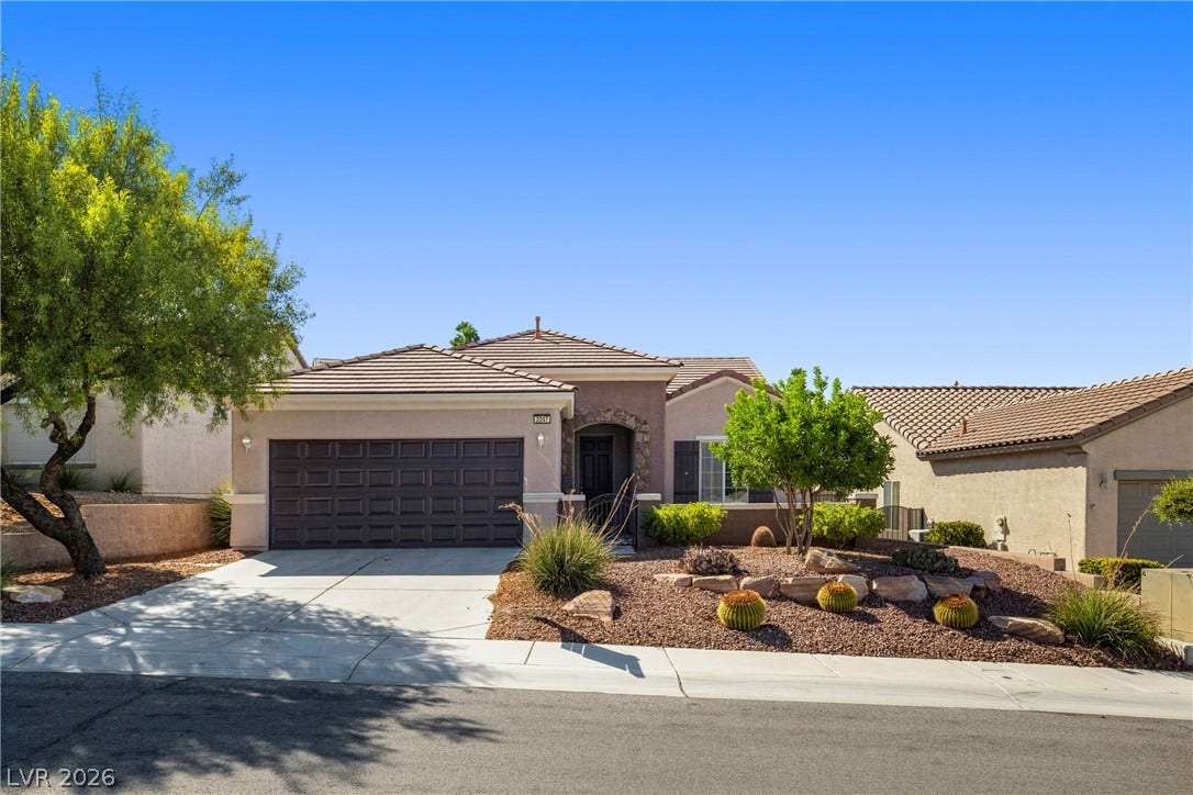 2247 Shadow Canyon Drive, Henderson, NV 89044 Desert landscaping and a concrete driveway lead to the tile-roofed residence with attached garage.