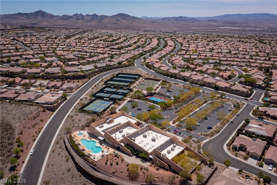 2247 Shadow Canyon Drive, Henderson, NV 89044 Aerial view showcasing neighborhood recreation facilities surrounded by a desert mountain landscape.