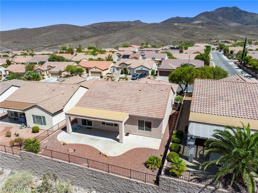 2247 Shadow Canyon Drive, Henderson, NV 89044 An elevated perspective highlights a tile roof and covered patio set against mountain backdrops.