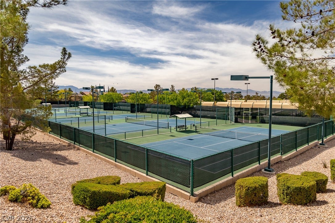 2247 Shadow Canyon Drive, Henderson, NV 89044 Fenced tennis courts stand ready for recreation beneath a expansive mountain backdrop.