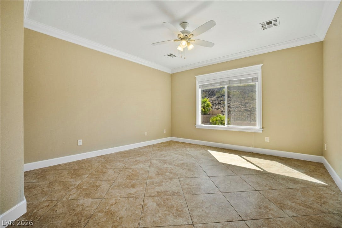 2247 Shadow Canyon Drive, Henderson, NV 89044 Tiled flooring and elegant crown molding define this versatile living space with a large window.