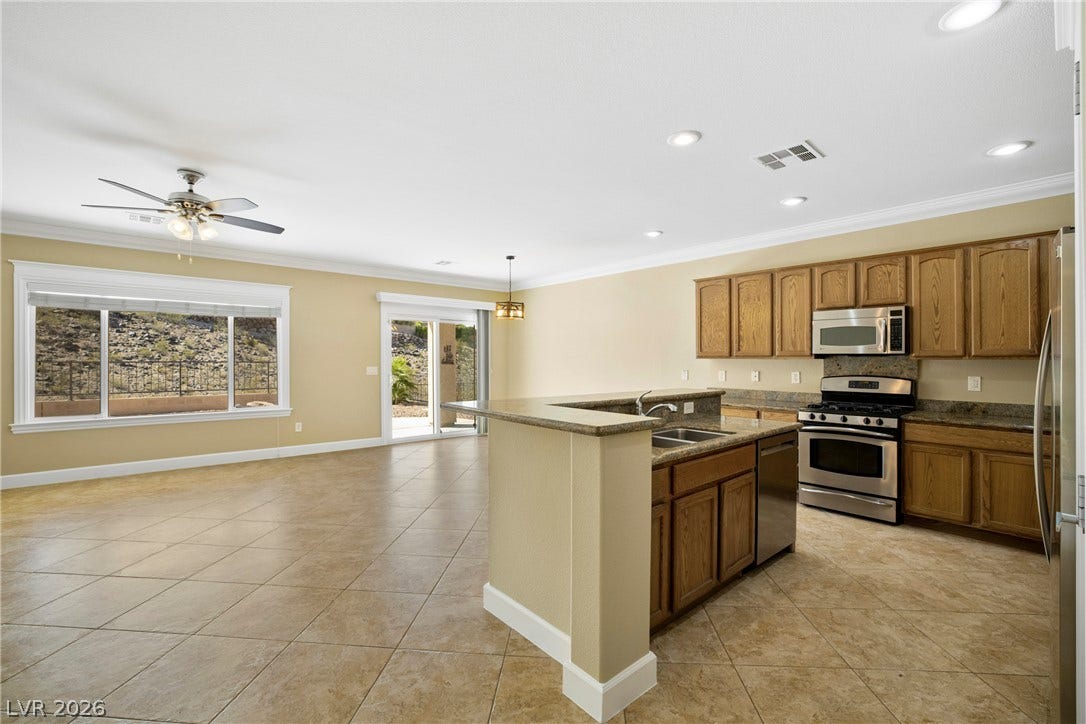 2247 Shadow Canyon Drive, Henderson, NV 89044 An open floor plan connects the kitchen to a spacious living area with tile flooring.