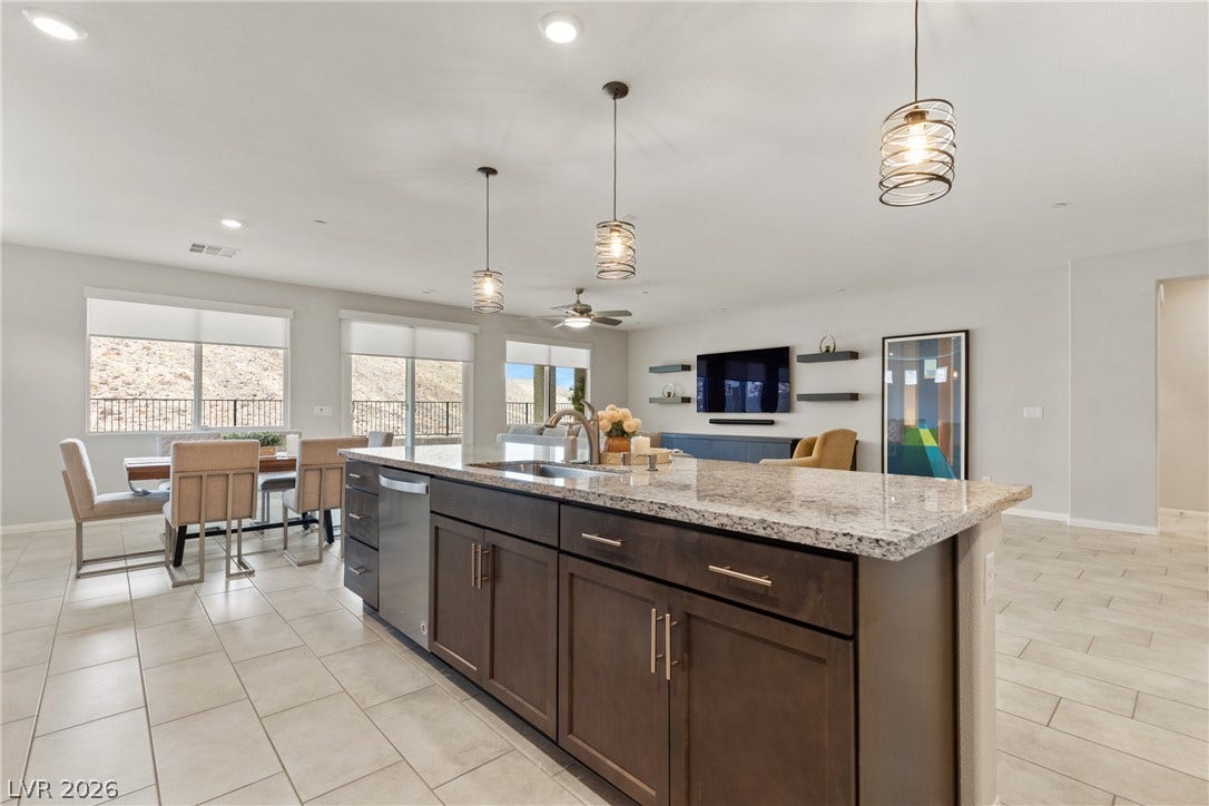 Polished stone countertops and seamless tile flooring anchor the open-concept layout.