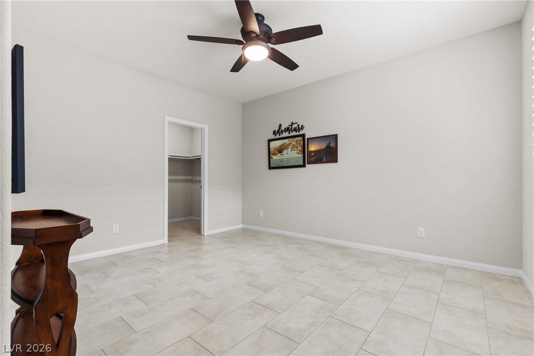 Smooth tile flooring sweeps across this versatile room leading to a walk-in closet.