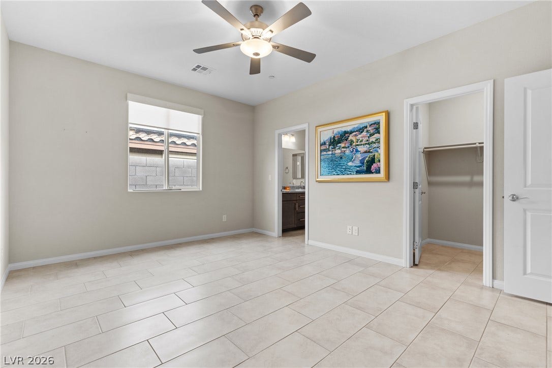 Tiled floors and neutral walls define this versatile space featuring access to a walk-in closet.