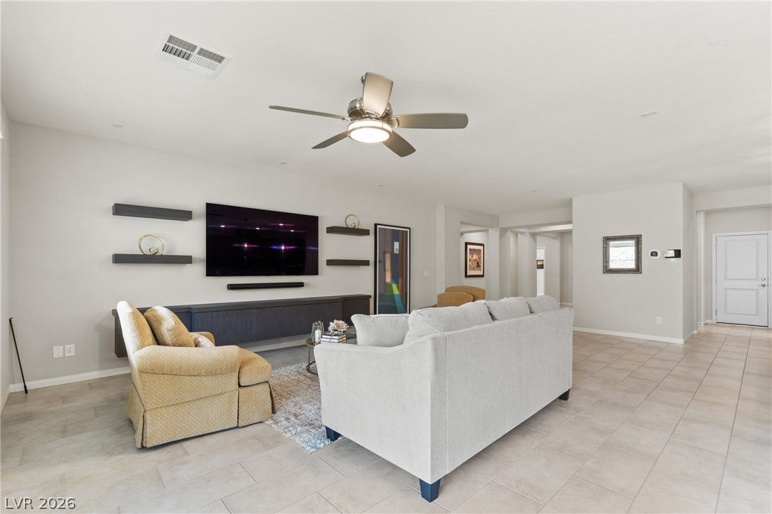 Smooth tile flooring and crisp white walls define this airy, open-concept living area.
