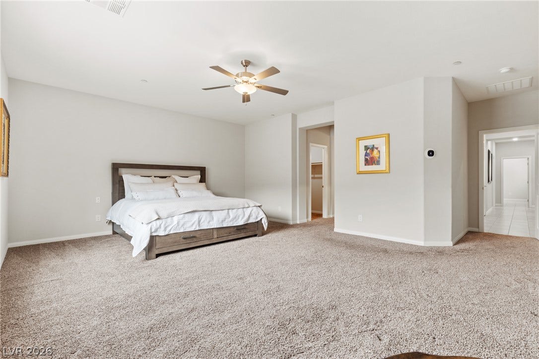 Plush carpeting anchors this spacious bedroom featuring clean lines and a neutral palette.