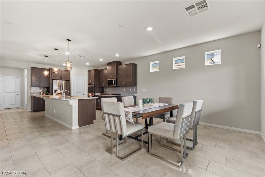 Smooth tile flooring extends across an open-concept layout connecting the dining space to the kitchen.