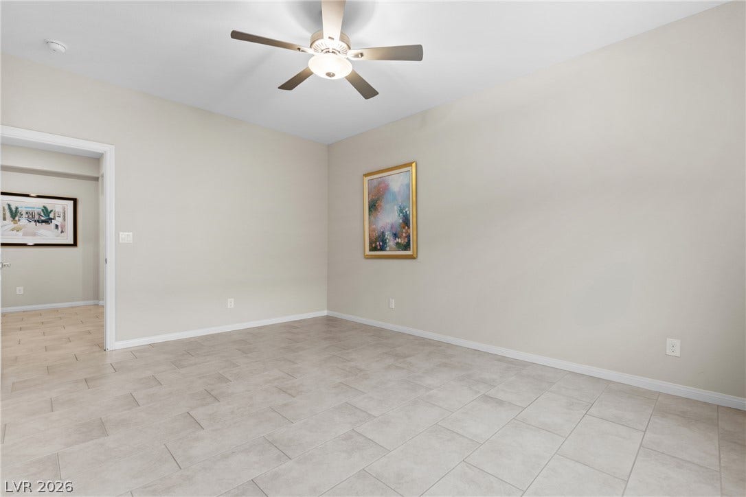 Durable tile flooring runs throughout this versatile space finished with classic baseboards.