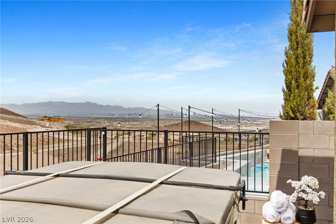 Distant mountains and city lights frame the elevated outdoor terrace.