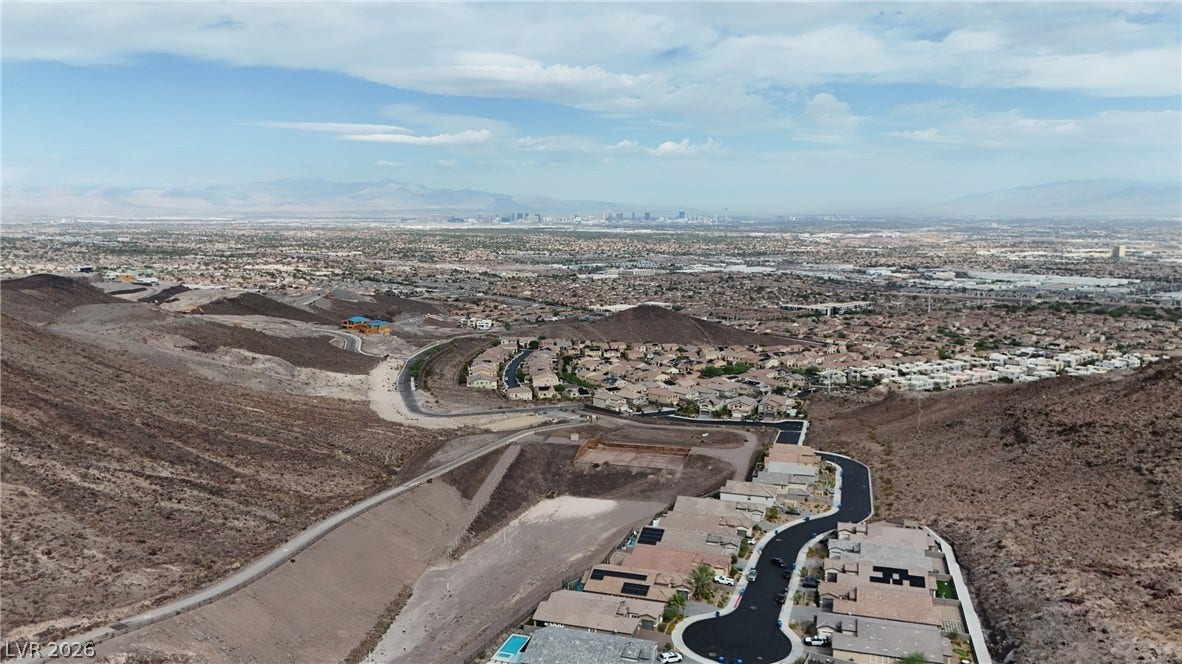 Vast desert hillsides frame sweeping views stretching all the way to the distant city skyline.