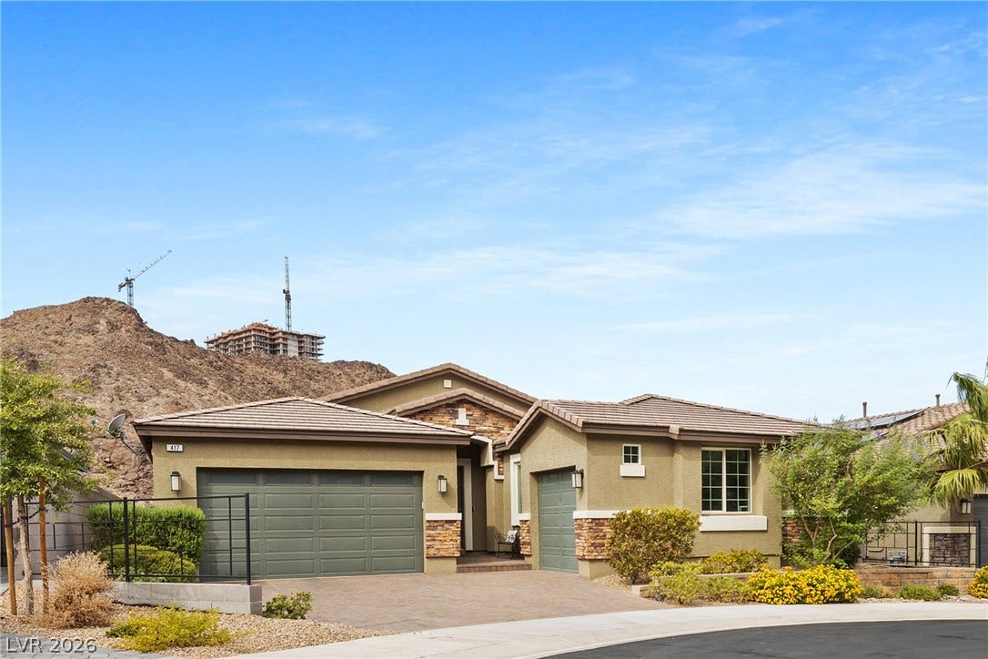 Desert-inspired masonry accents and tiled rooflines define this modern single-story exterior.