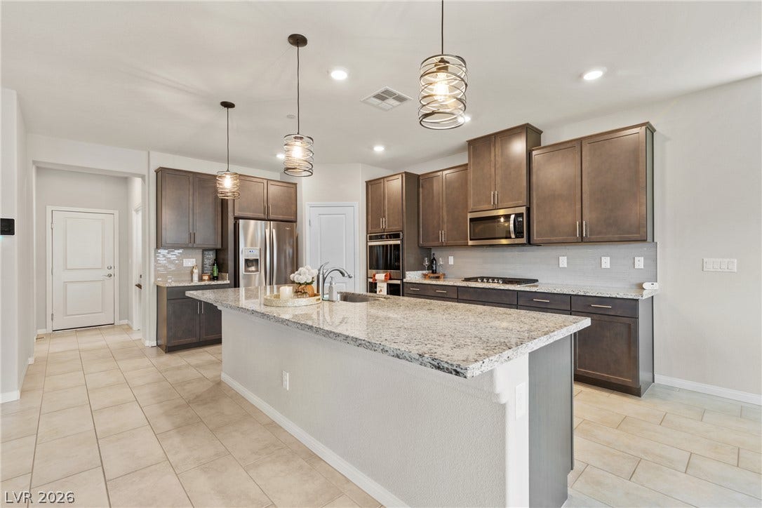 Gleaming granite countertops pair beautifully with custom cabinetry in this spacious kitchen.