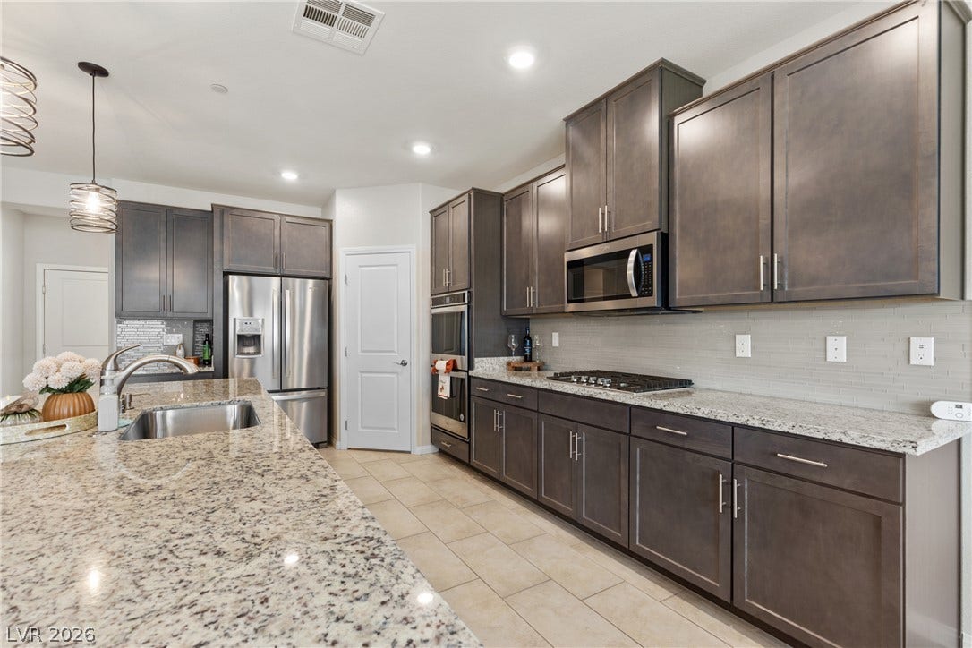 Gleaming granite countertops pair beautifully with modern dark cabinetry and tile flooring.