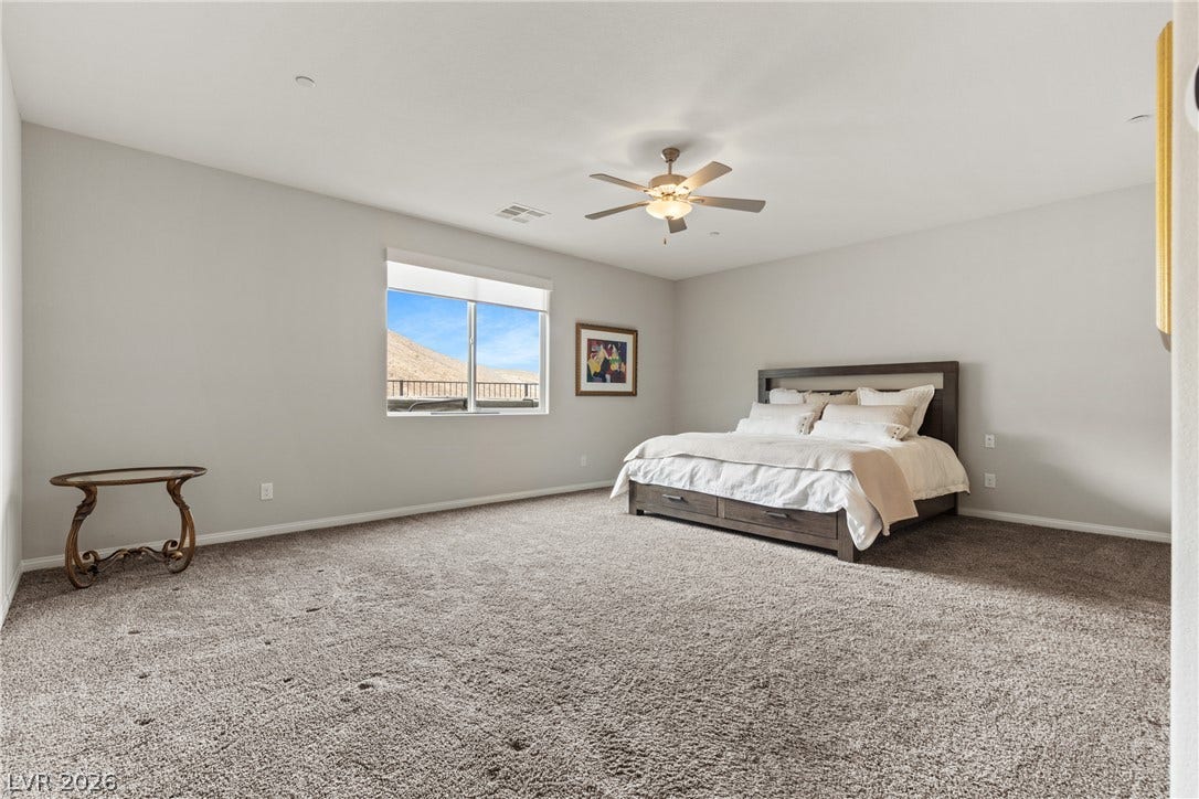 Plush carpeting and elevated ceilings define this airy bedroom retreat.