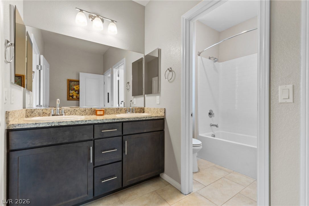Double vanities and a private tub area define this well-appointed bathroom space.