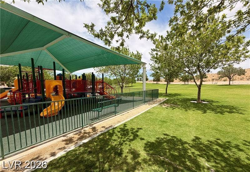 10605 Bardilino Street, Las Vegas, NV 89141 Shaded playground equipment borders an expansive grassy park under a blue sky.