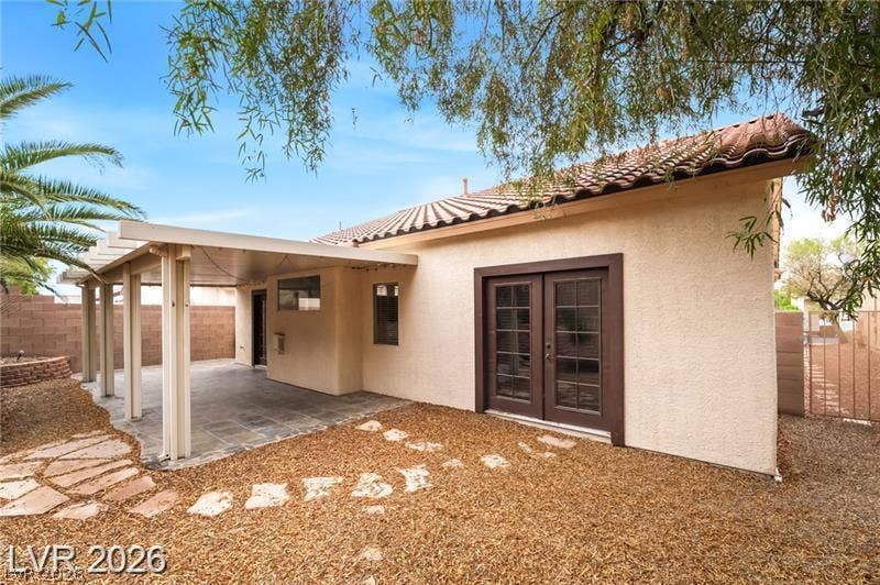 10605 Bardilino Street, Las Vegas, NV 89141 French doors open to a tiled covered patio overlooking the low-maintenance yard.