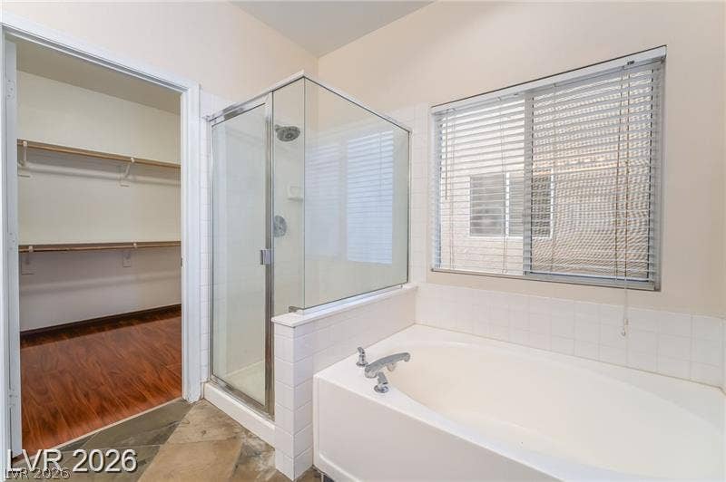 10605 Bardilino Street, Las Vegas, NV 89141 A spacious soaking tub sits adjacent to a glass-enclosed shower stall and a walk-in closet.