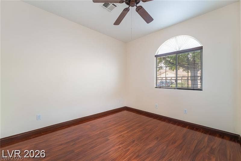 10605 Bardilino Street, Las Vegas, NV 89141 Warm wood flooring and an arched window define this versatile secondary bedroom space.