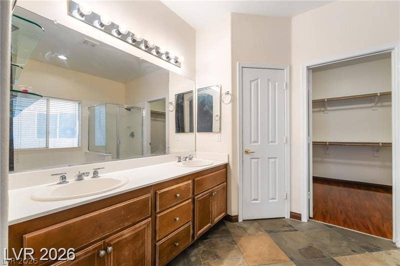 10605 Bardilino Street, Las Vegas, NV 89141 Natural stone tile floors and a generous double vanity anchor this master bathroom suite.