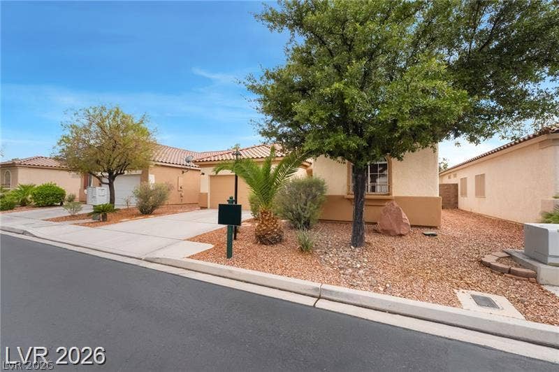 10605 Bardilino Street, Las Vegas, NV 89141 Desert plantings frame a classic stucco exterior under a clear blue sky.
