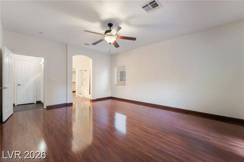 10605 Bardilino Street, Las Vegas, NV 89141 Polished hardwood flooring spans a bedroom featuring an arched doorway leading to an en suite bath.
