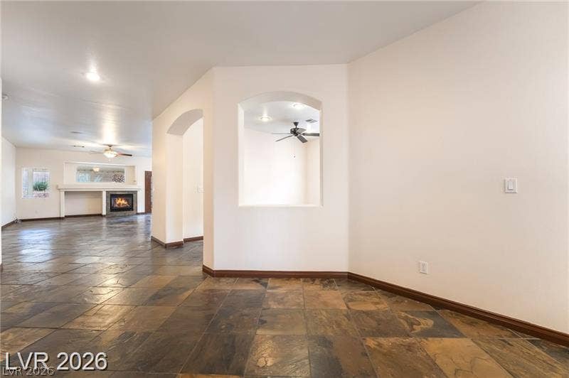 10605 Bardilino Street, Las Vegas, NV 89141 Textured tile flooring guides the eye through arched transitions and toward a distant fireplace.