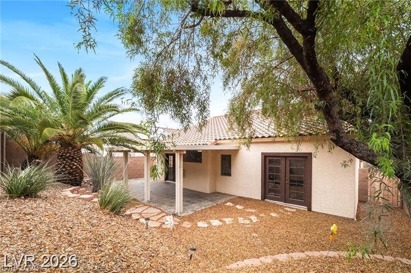 10605 Bardilino Street, Las Vegas, NV 89141 Lush mature trees shade a tile patio and stucco exterior under a classic tiled roof.
