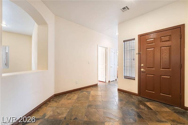 10605 Bardilino Street, Las Vegas, NV 89141 Rich slate tile flooring and arched architectural cutouts elevate this welcoming entry hall.